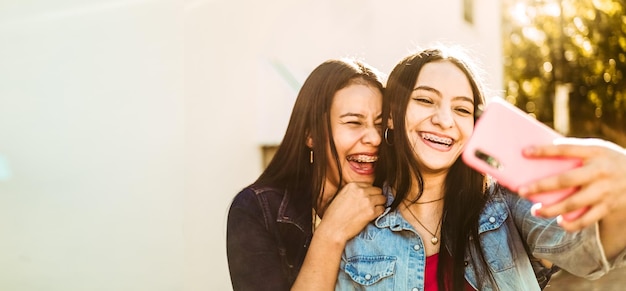 Hispanic women together taking a selfie with copy space friendship concept.