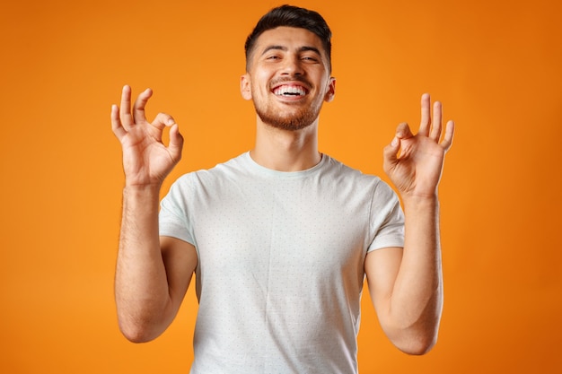 Hispanic young handsome man singing with joy in microphone