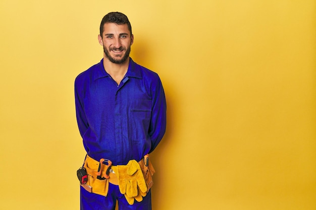 Photo hispanic young man in blue work jumpsuit with tools