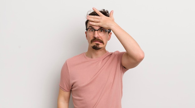 Hispanic young man panicking over a forgotten deadline feeling stressed having to cover up a mess or mistake