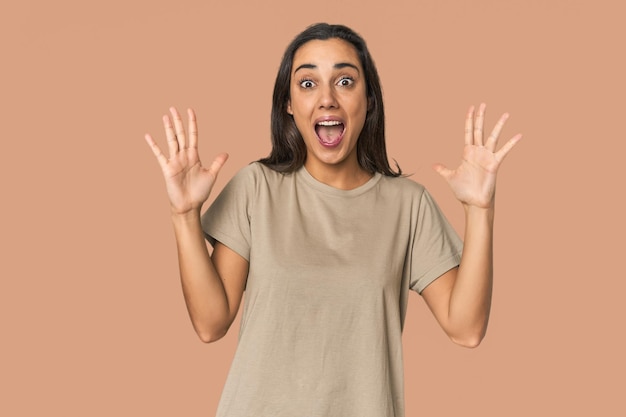 Photo hispanic young woman celebrating a victory or success he is surprised and shocked