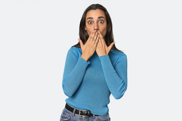 新たな何かを発見したいと思って口を手で覆う若いヒスパニック系女性がショックを受けました
