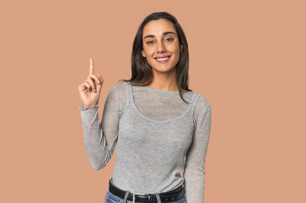 Hispanic young woman showing number one with finger