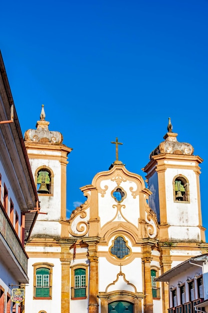 Историческая церковь в стиле барокко и окружающие колониальные дома в городе Оуро-Прето в Минас-Жерайсе