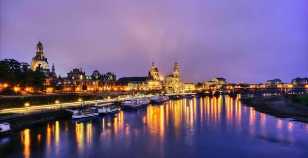 historic buildings by river against sky in city at dusk