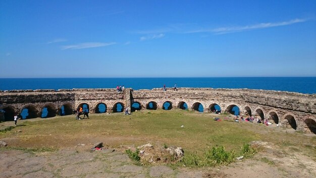 Historic built structure by sea against sky