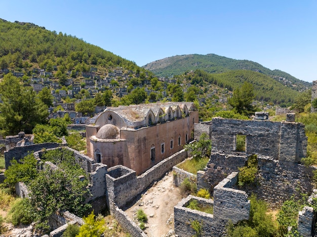 カヤコイの歴史的リキア村 (Fethiye, Mugla, トルコ) - ゴーストタウンカヤコイのドローン撮影古代石の街の夕方の気分の温かい太陽