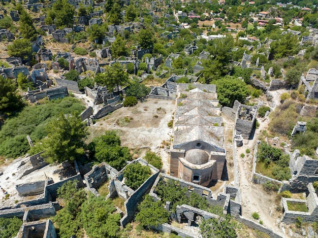 Historical Lycian village of Kayakoy, Fethiye, Mugla, Turkey. Drone aerial shot from above of the Ghost Town Kayakoy. Greek Village. Evening moody warm sun of the ancient city of stone