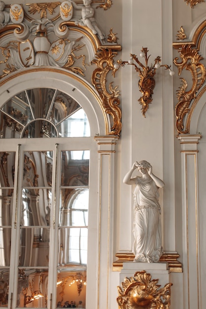 Historisch gouden wit het interieur van het State Hermitage Museum met marmeren standbeeld Historische plaats