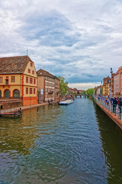 Historisch Museum aan de waterkant van de Ill River en de Pont du Corbeau-brug in de oude stad van Straatsburg, Grand East-regio in Frankrijk. Mensen op de achtergrond