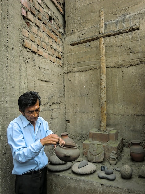 Insegnante di storia che mostra manufatti - antichi strumenti degli incas in un museo in perù.