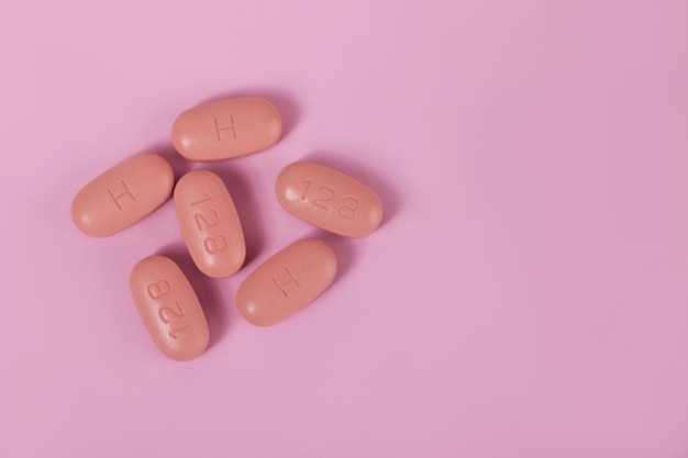 HIV/AIDS therapy pills on pink background