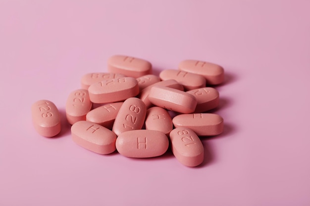 HIV AIDS therapy pills on pink background