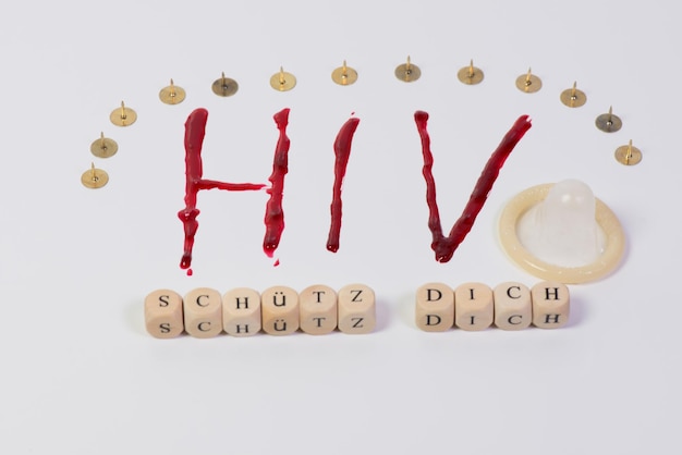 Foto hiv-tekst door condooms en speelgoedblokken met rechte pinnen op witte achtergrond