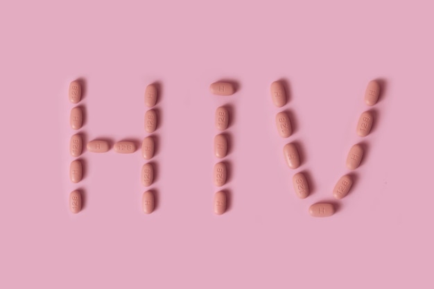 Photo hiv therapy pills on pink background