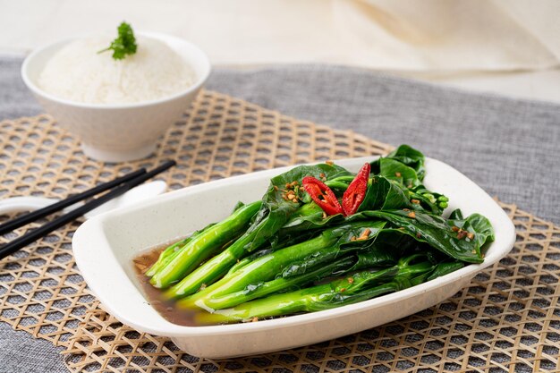 HK KAI LAN W GARLIC OYSTER SAUCE with chopsticks served in dish isolated on table top view of singapore food