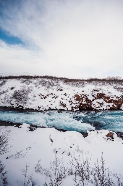Hlauptungufoss waterfall the \'iceland\'s bluest waterfall\' blue\
water flows over stones winter iceland visit iceland hiking to\
bruarfoss waterfall