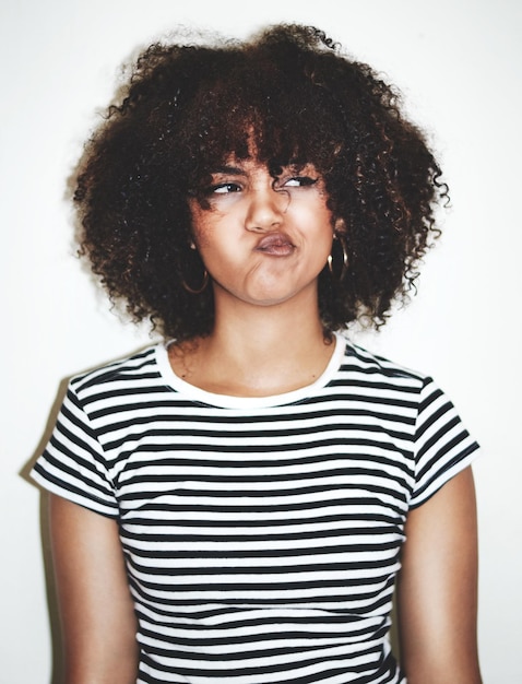 Photo hmmi dont see that happening studio shot of a young woman pulling faces against a gray background