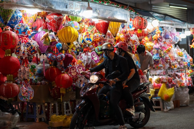 Ho Chi Minh City Vietnam 31 Aug 2023 People in front of traditional colorful lanterns hanging on a stand in the streets of during Mid Autumn Festival Joyful and happy Selective focus