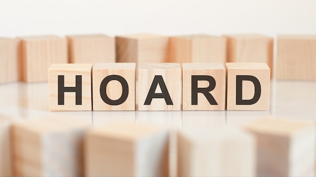 Hoard - houten letters op het bureau, witte achtergrond, concept