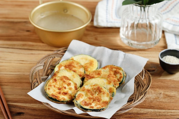 Photo hobak jeon or pan fried zucchini served with makgeolli