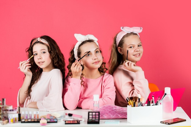 Hobby and fun Happy girls doing makeup Cute sisters play with cosmetics Beauty salon Sisterhood happiness Skin care Beauty routine Kids makeup Cosmetics for children Beauty and fashion