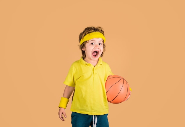 趣味のスポーツコンセプトの子供は、ボールスポーツでバスケットボールのスポーティな男の子と遊ぶバスケットボールの子供を保持します