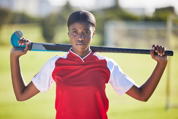 Hockey player or coach holding stick ready for a competition or match on the sports ground or field Portrait of a serious fit and active black woman athlete at fitness training exercise or workout