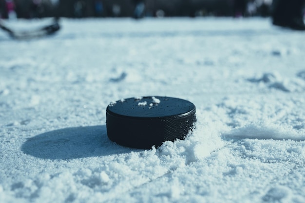 Фото Хоккейная шайба лежит на снегу крупным планом