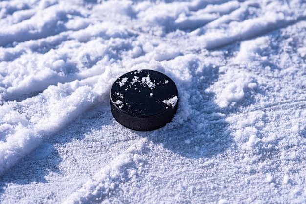 Hockey puck lies on the snow closeup