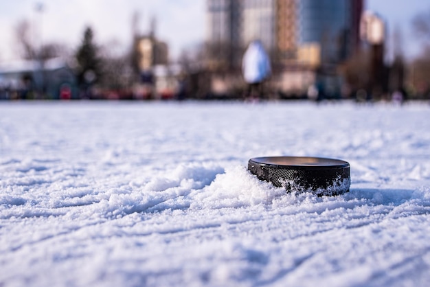 Hockey puck lies on the snow macro