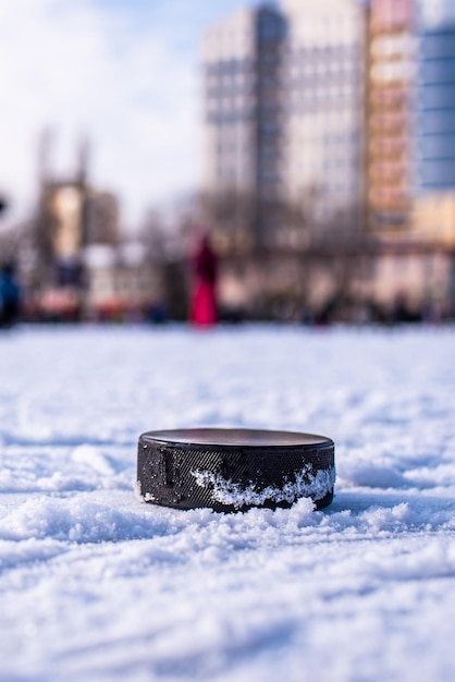 Hockey puck lies on the snow macro