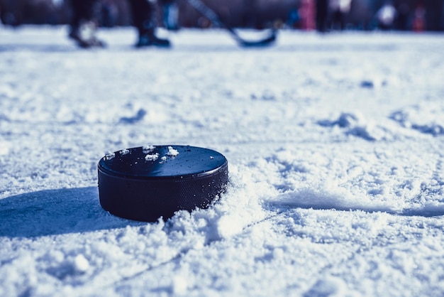 Hockey puck lies on the snow macro