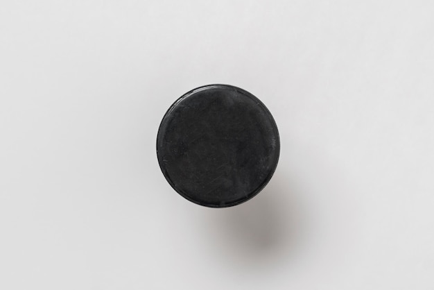 A hockey sport black rubber puck isolated close up view