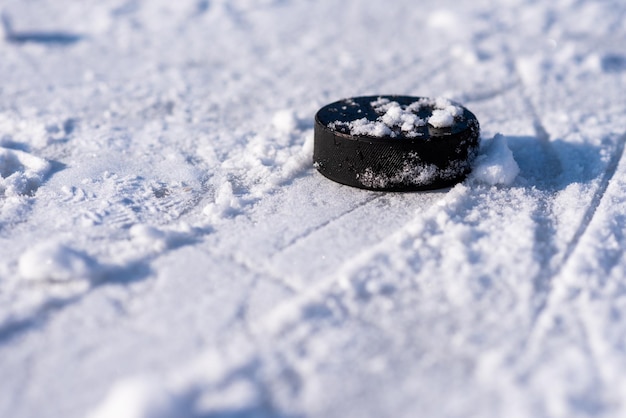 Hockeypuck ligt op de sneeuwclose-up