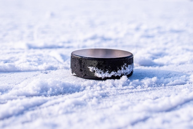 Hockeypuck ligt op de sneeuwclose-up