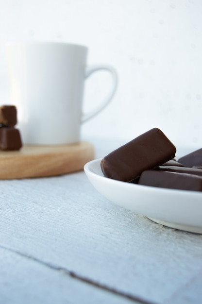 hocolates on plate on light background