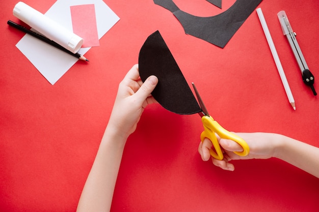 Hoe je thuis vleermuis van papier kunt maken. Handen die ambacht van papier maken. Stap voor stap foto-instructie. Stap 3. Snijd de cirkels in twee delen. Kinderen DIY-kunstproject