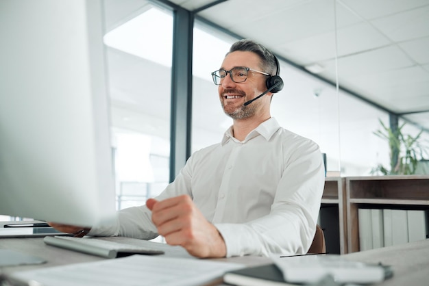 Hoe kan ik u vandaag van dienst zijn Shot van een volwassen medewerker van de klantenservice die alleen op kantoor zit en zijn computer gebruikt