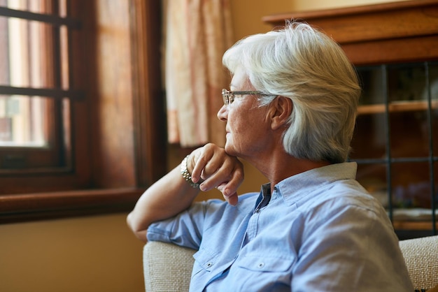 Hoe meer je reflecteert, hoe meer je je realiseert bijgesneden opname van een oudere vrouw die thuis uit het raam kijkt