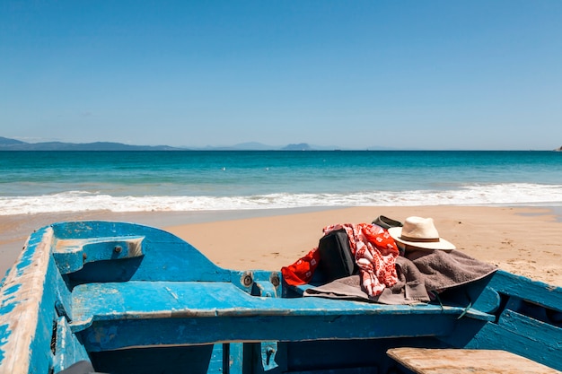 Foto hoed en handdoek op boot op het strand