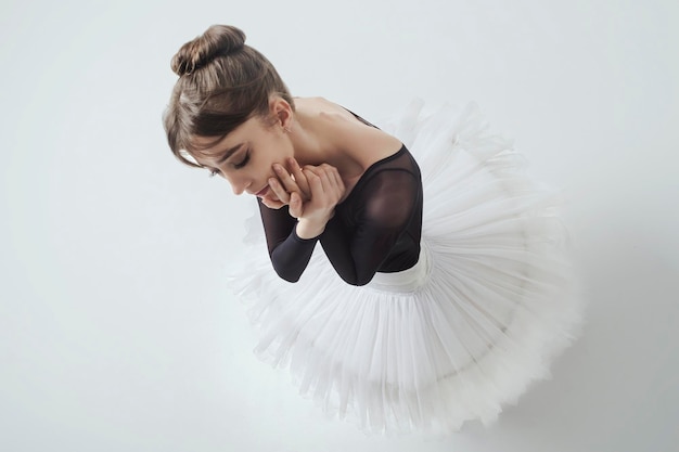 Hoek van bovenaf op een ballerina tot aan de taille met haar handen die een dans laten zien