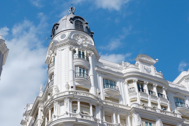 Hoek van elegant oud gebouw met afgeronde vormen in balkonstructuur in het centrum van Madrid, Spanje