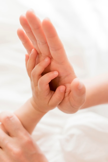 Hoge hoek moeder bedrijf baby's hand