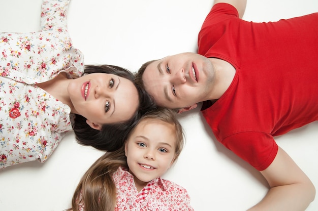 Hoge hoek portret van gelukkige familie liggend op witte achtergrond