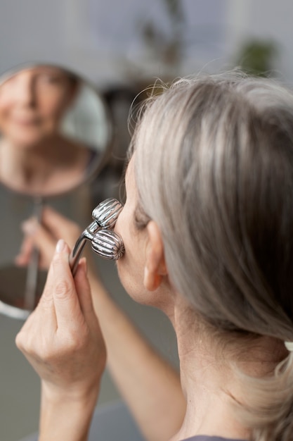 Hoge hoek senior vrouw die gezicht masseert