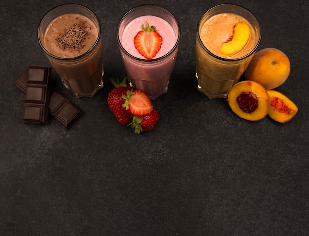 Foto hoge hoek van assortiment milkshakes met fruit en chocolade