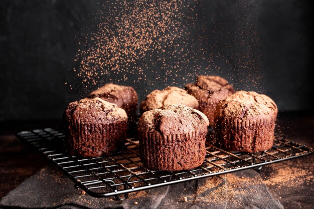 Hoge hoek van chocolademuffins op koelrek in poedervorm met cacao