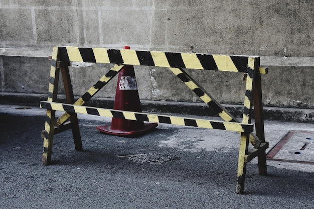 Hoge hoek van de barricade met verkeerskegel op de weg tegen de muur
