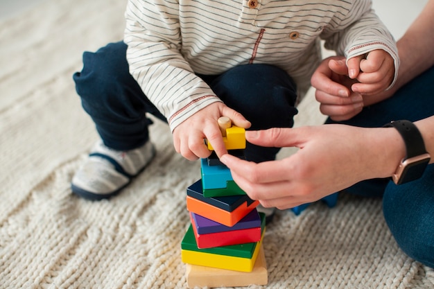 Hoge hoek van kind spelen thuis met moeder